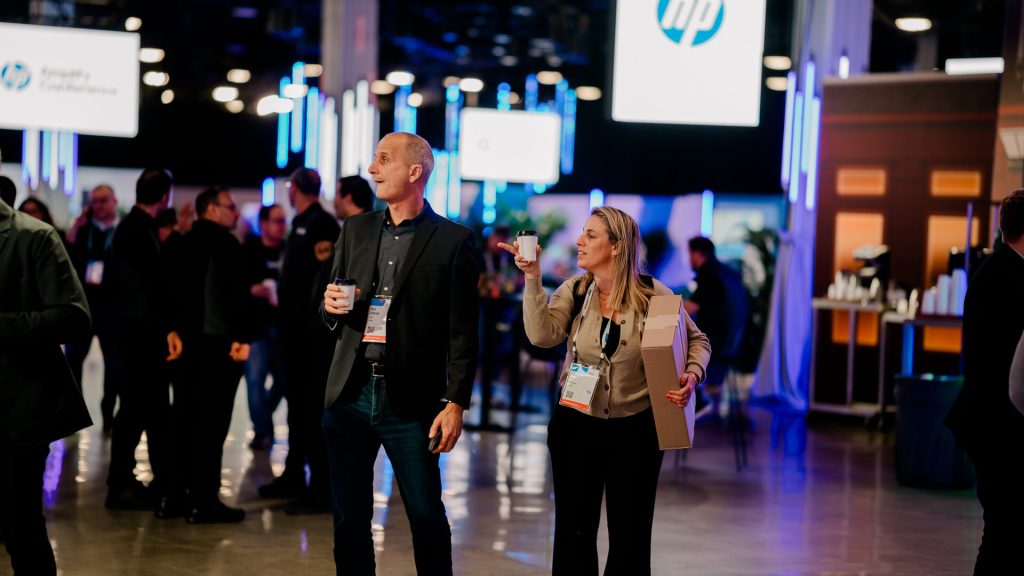Attendees walking with drinks at hp amplify conference