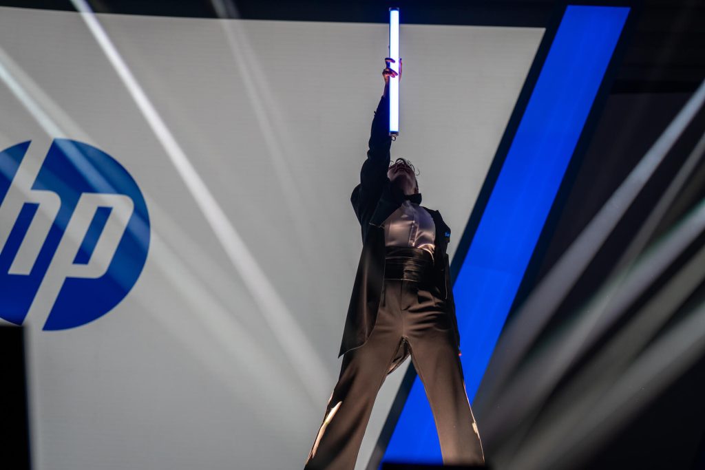 Performer holding light stick on stage at hp event