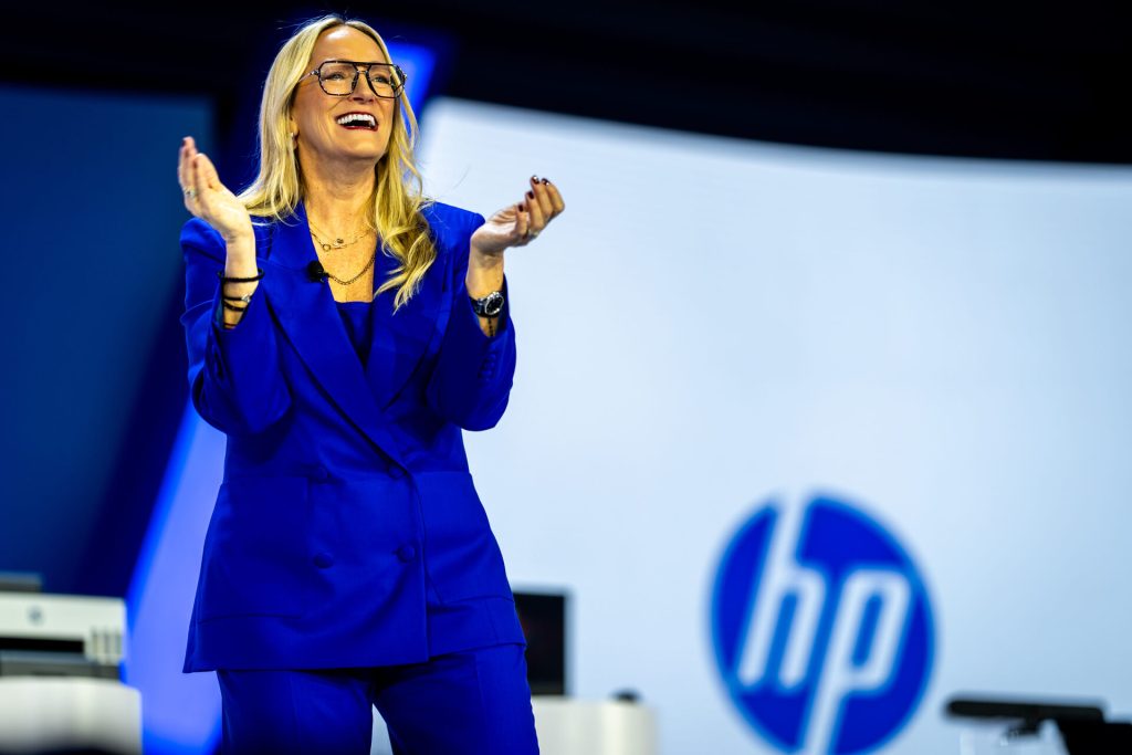 Woman in blue suit speaking on stage at hp amplify conference